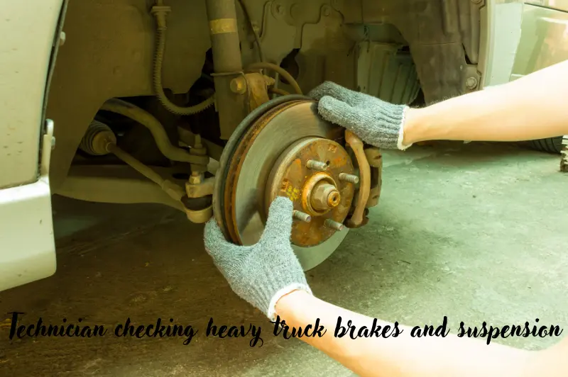 technician checking heavy truck brakes and suspension